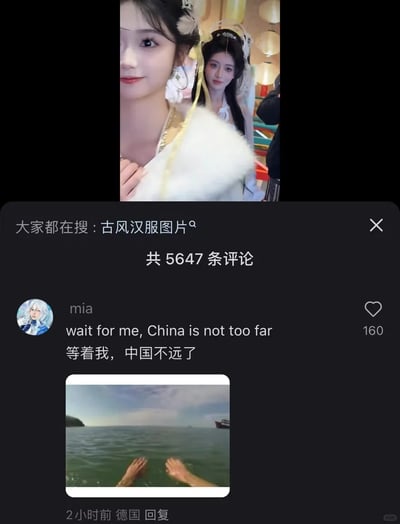 这是一张短视频平台评论区的截图，画面顶部是两位身着精致古风汉服造型的女性的视频片段，她们面带微笑看向镜头，其中一位手搭在白色毛领服饰上。评论区顶部显示“大家都在搜：古风汉服图片”，并标注共有5647条评论。用户名为mia的网友（IP显示来自德国，2小时前发布评论）发布了内容为英文“wait for me, China is not too far”与中文“等着我，中国不远了”的评论，还附带了一张双手置于海水中、模拟游泳动作的图片，用玩梗的趣味方式表达自己想要来到中国的期待，这条评论获得了160个点赞。