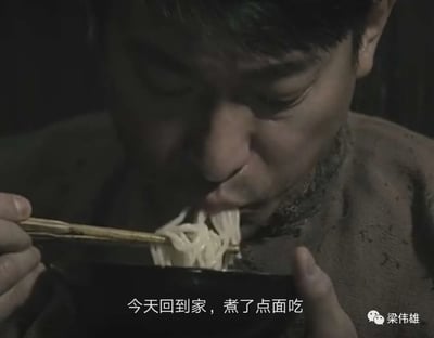 昏暗的环境中，一名男子低头用筷子夹起面条送入口中，神情落寞。图片下方配有字幕“今天回到家，煮了点面吃”，这一场景是“关灯吃面”梗的经典视觉化呈现，原本用于表达股民投资失败后的绝望情绪，后演变为表达各种失意场景的流行语。