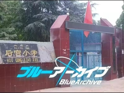 图片展示了大马乡后宫小学的校门场景。红色砖墙围合的校门上方飘扬着一面红旗，左侧石碑上刻有金色的“后宫小学”及拼音“HOU GONG XIAO XUE”字样。图片下方叠加了游戏《蔚蓝档案》（ブルーアーカイブ）的日文标题和英文logo，形成趣味联动。

**谐音梗解析**：“后宫”一词在中文语境中除指古代帝王的妃嫔住所外，也常被网友用来调侃“拥有多位女性角色的作品设定”，而《蔚蓝档案》恰好以管理女学生组织为核心玩法，校名与游戏主题的意外契合产生了幽默效果。