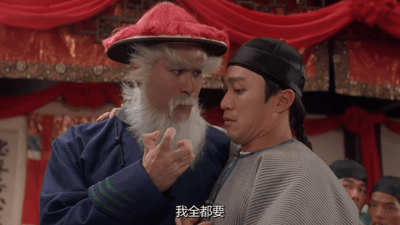 电影《九品芝麻官》中的经典场景，画面中一位戴着红帽、留着长长白胡子的老者（豹头雷豹）正紧紧抓住另一位穿着灰色条纹长袍的男子（周星驰饰）的肩膀，老者伸出手指，表情坚定。画面底部有字幕“我全都要”，完美展现了面对选择时想要全部拥有的心态。
