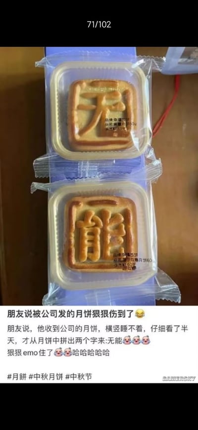 图片展示了两盒独立包装的方形月饼，上层月饼表面印有清晰的'天'字，下层月饼印有'能'字，均为传统月饼样式，放置于浅色桌面上。图片下方配有文字描述朋友收到公司发放的月饼后，因两个月饼上的字可组合成'无能'（谐音双关，暗指能力不足）而感到被'狠狠伤到'，引发emo情绪的趣事。
双关/谐音梗：两个月饼上的'天'与'能'上下排列，被巧妙解读为'无能'（原应为'天能'，此处通过断句和语义联想形成幽默吐槽），利用文字组合制造笑点和共鸣。