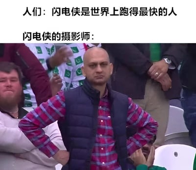 这张梗图上方有两行文字："人们：闪电侠是世界上跑得最快的人"和"闪电侠的摄影师："，下方是一张体育场观众席的照片。照片中一名光头男子穿着格子衬衫和深色马甲，双手叉腰，表情严肃地站在那里。图片通过幽默的对比暗示：如果闪电侠是世界上跑得最快的人，那能拍到他的摄影师一定更快，形成了有趣的逻辑反转笑点。