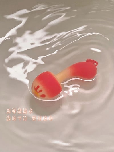 一张展示红色玩具漂浮在水中的图片，玩具呈现出蘑菇状，主体为红色，顶部有黄色和红色的装饰图案。水面上有自然的波纹和光影反射，营造出清新干净的视觉效果。图片底部有橙色文字："高等级防水 洗的干净 玩得放心"，突出产品的防水特性和安全性。