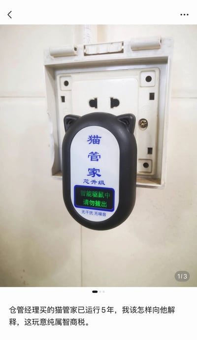 整张图是移动端社交媒体内容截图，上半部分实拍了一个插在墙面插座上的黑色猫耳造型驱鼠器，驱鼠器正面印有“猫管家 芯升级”的蓝色文字，绿色显示屏显示“智能驱鼠中 请勿拔出”，底部标注“无干扰 无噪音”；下半部分是发布者配的文案，内容为“仓管经理买的猫管家已运行5年，我该怎样向他解释，这玩意纯属智商税”，右下角标注该内容为组图的第1张。