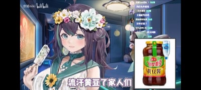 这是B站虚拟主播奈姬niki的直播画面截图，图中奈姬头戴鲜花花环，手持冰棍，面带微笑看向镜头；画面右侧拼接了一张经过P图改编的海天黄豆酱图片，将酱的瓶盖替换成了桶装水的样式，搭配下方文字“流汗黄豆了家人们”，玩了谐音梗：“流汗黄豆”是网络上表达无奈、尴尬情绪的经典表情包，这里用“黄豆酱+桶装水（对应‘流‘汗’’）”的创意P图来谐音这个热梗，把抽象的情绪用具象的品牌元素呈现，充满搞笑感。画面右侧还显示了B站直播的观众弹幕，进一步烘托直播玩梗的氛围。