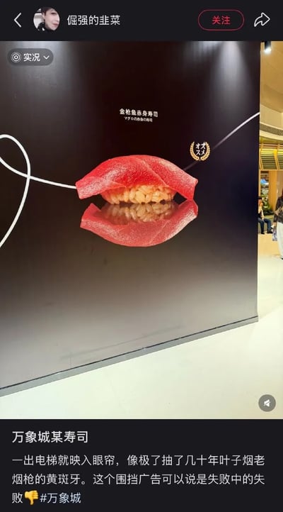 这是一张社交媒体平台的截图，用户「倔强的韭菜」发布了万象城某寿司店的围挡广告实拍图。广告将金枪鱼赤身寿司设计成类似嘴唇的造型，用户配文吐槽该造型像极了抽了几十年叶子烟的老烟枪的黄斑牙，称这个围挡广告是「失败中的失败」，并配上倒赞表情，充满了搞笑的吐槽意味。