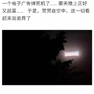 这是一则图文结合的趣味内容，上方配文描述了事件背景：起雾的夜晚，电子广告牌发生死机故障。下方的实拍图片中，雾气弥漫的黑夜里，树木的黑影旁，故障的电子广告牌亮起，显示出类似电脑系统加载或崩溃的进度条界面，在夜色与雾气的烘托下，这个发光的界面仿佛悬浮于天空中的“系统窗口”，营造出一种荒诞又诡异的趣味氛围，让日常的设备故障场景变得充满奇幻感。