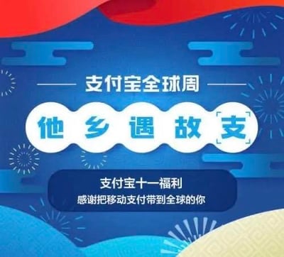 这是一张支付宝全球周的促销宣传海报，背景为蓝色，点缀有祥云和烟花等喜庆装饰元素。海报上方标题为“支付宝全球周”，中央核心文字区域以白色波浪边框突出显示“他乡遇故支”（谐音“他乡遇故知”，将“知”替换为“支”以关联支付宝品牌），下方配有“支付宝十一福利 感谢把移动支付带到全球的你”的副标题，整体风格喜庆，旨在推广支付宝的全球业务并感谢用户支持。