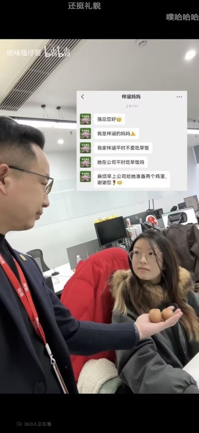 整张图是职场搞笑类短视频截图，场景为普通办公区，画面上方叠加了微信聊天记录界面，显示备注为“梓涵妈妈”的用户给公司强总发消息：先礼貌问好，表明自己是员工梓涵的母亲，称梓涵平日不爱吃早饭，询问梓涵在公司是否吃早饭，最后请求公司早上给梓涵准备两个鸡蛋并致谢。画面下方实景中，佩戴工牌、身着正装的男性（即强总）手掌托着两个鸡蛋，递向坐在工位上的女员工梓涵，梓涵表情茫然无奈，略显尴尬。图顶部有观众弹幕“还挺礼貌”“噗哈哈哈”，左上角有UP主“绝味强仔哥”和B站标识的水印，底部显示有363人正在观看该视频。