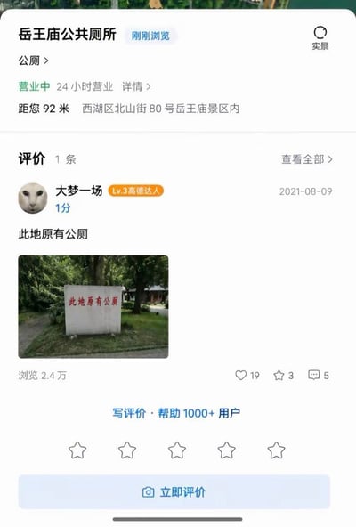 这是一张高德地图商家详情页的手机截图，展示的是杭州岳王庙景区内公共厕所的页面信息：页面顶部标注该公厕处于营业中、24小时营业，地址为西湖区北山街80号岳王庙景区内，距离查询用户92米；页面下方仅有的一条用户评价由Lv3高德达人“大梦一场”在2021年8月9日发布，给出1分最低评分，评价内容为“此地原有公厕”，还附带了现场实拍的石碑照片，石碑上同样印有红色字样“此地原有公厕”，暗指该公厕实际已经不存在，地图信息标注有误；这条评价累计有2.4万次浏览，获得19个点赞、3次收藏、5条评论，页面底部还有评价输入入口。