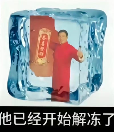 图中呈现了一个被冻在冰块里的穿红色中式长衫的男子，他一手举着写有“恭喜发财”的竖幅，一手拿着小酒瓶，面带笑容；冰块下方配有文字“他已经开始解冻了”。这是网友的二次创作梗图，用“解冻”来调侃春节相关的拜年形象在特定时机“复苏”，整体氛围搞笑又带有喜庆感，没有双关或谐音梗。