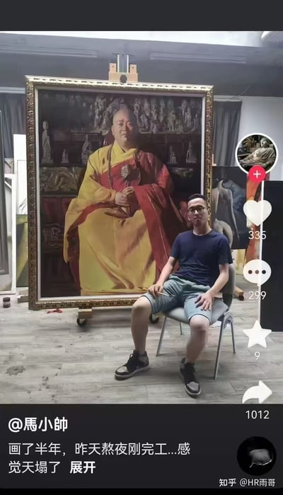 图片展示了一位男性创作者坐在椅子上，身后是他刚完成的大型油画作品。画作中是一位身着黄色僧袍、红色袈裟的人物，背景布满佛像雕塑。创作者穿着蓝色T恤和浅蓝色短裤，神情疲惫地看向镜头，左手搭在膝盖上，右手握着画笔。图片右侧有社交媒体互动按钮（点赞335、评论299、分享1012），底部显示用户@马小帅的配文：“画了半年，昨天熬夜刚完工...感觉天塌了 展开”。整体场景呈现出艺术创作完成后的疲惫与成就感。
