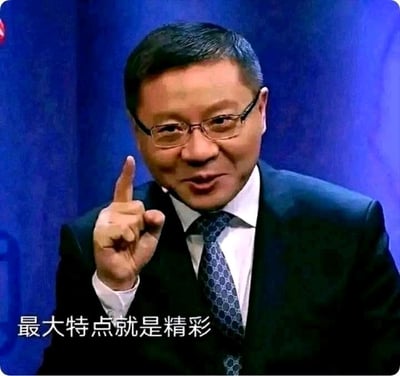 图片中是一位穿着深色西装、戴着眼镜的中年男性，他正用右手食指向上指着，表情自信。人物身后是蓝色背景，图片底部有白色文字“最大特点就是精彩”。