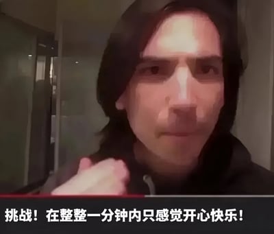 图片中显示一名穿着连帽衫的长发人士，表情严肃地看着镜头，似乎正在自拍或录制视频。图片底部有一行文字：'挑战！在整整一分钟内只感觉开心快乐！'，形成了人物表情与文字内容的有趣对比。