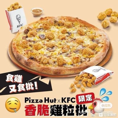 这是一张必胜客（Pizza Hut）与肯德基（KFC）的跨界联名新品宣传图，主体是一款铺满肯德基经典香脆鸡粒（鸡米花）、蘑菇与芝士的披萨，放置在木质托盘上。披萨周围摆放着肯德基包装的鸡米花和一小份蘸酱，还有散落的鸡粒。图中配有醒目的宣传文字：“食雞又食批！”（为粤语表述，意为‘吃鸡又吃披萨’，港澳地区常用‘批’指代披萨），以及‘Pizza Hut×KFC 限定 香脆雞粒批’的字样，明确这是双方联名的限定产品。左下角有流口水的表情，右下角有小红书平台的水印、用户ID，还有一只带有水滴特效的惊讶卡通小鸡，整体风格活泼诱人，旨在结合两个快餐品牌的经典产品，打造话题性，吸引消费者关注并尝试这款联名披萨。