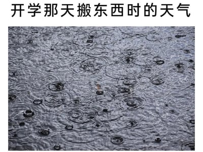 图片上方有文字'开学那天搬东西时的天气'，下方是一张雨天地面的照片，雨滴落在湿润的地面上形成密集的水波纹，生动展现了开学搬运行李时遇到下雨天的场景，带有无奈和吐槽的意味。