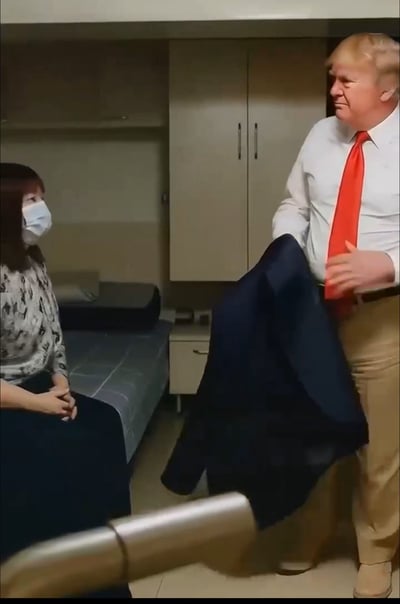 这张图片拍摄于一个看起来像宿舍或小型办公室的空间内，画面中一名穿白衬衫、系着红色领带的男性站立，手里拿着西装外套，面对着一名坐在床上的女性。气氛略显紧张或尴尬，通常用来表达职场、生活中被领导或上级叫去谈话的不安和压力。图片经常被网友用于二次创作，搭配各种尴尬或搞笑的网络段子。当前图像无明显双关语或谐音梗，但整体画面容易让人联想到心理压力或被批评的情境，具有一定暗示意味。适合用来调侃‘领导叫谈话’、‘即将被上级问话’等情景。