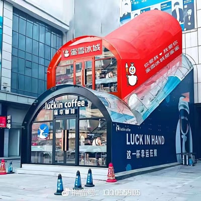 这是一张AI生成的视觉错位创意图，下层是蓝黑色调的瑞幸咖啡门店，上层是红色的蜜雪冰城门店，两者的弧形结构与镜面材质搭配，营造出蜜雪冰城“套在”瑞幸咖啡门店上方的错觉，画面趣味十足。蜜雪冰城墙面印有品牌经典雪王形象和“你爱我 ❤ 我爱你 蜜雪冰城甜蜜蜜”的标语，瑞幸咖啡则展示了蓝底白鹿标识与“LUCK IN HAND 这一杯幸运在握”的宣传语，门店内可见顾客身影，将两个国民品牌结合，带来新奇吸睛的视觉体验。