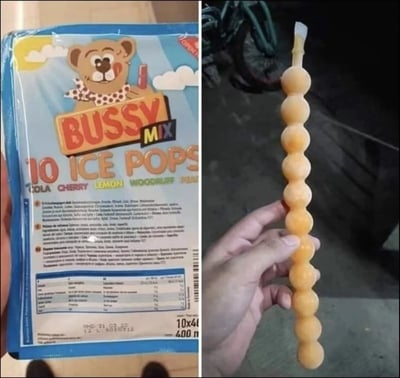 这是一张左右拼接的静态对比图，左侧展示的是“BUSSY MIX 10 ICE POPS”的冰棒外包装，包装设计可爱，带有卡通小熊形象，标注了可乐、樱桃、柠檬等多种口味，说明内含10支冰棒，下方还有详细的成分说明文字；右侧则是实际取出的该品牌冰棒，形态为多个淡黄色球状冰体串联在一起，和常规冰棒的形态有较大差异，形成了包装预期与实物的趣味反差，引发对食品包装与实物不符的调侃。