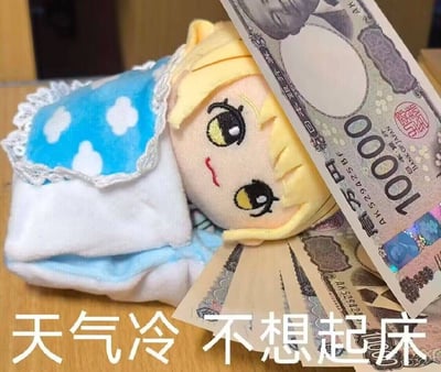 图片中展示了一个黄色头发的毛绒玩具，它穿着带有白色云朵图案的蓝色衣物，边缘有蕾丝花边装饰，正“躺”在类似床铺的柔软表面上，表情看起来有些困倦慵懒。玩具旁边散落着几张10000日元的钞票，部分钞票轻轻搭在玩具身上。图片底部有白色文字“天气冷 不想起床”，整体营造出一种天冷时连可爱的毛绒玩具都赖床不起的幽默场景，仿佛即使有金钱诱惑也无法让它离开温暖的“被窝”。
