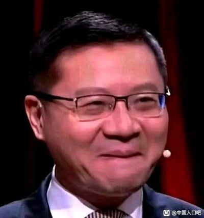 这张图是科普博主、中学教师李永乐的视频截图，他戴着眼镜，嘴角抿起，露出一种略带尴尬、又有点隐忍的微笑表情，常被网友用作表情包，用来表达尴尬、无语、勉强认同等复杂情绪，图中没有双关、谐音梗或暗示内容。