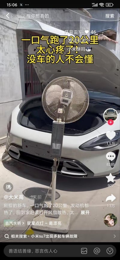 这是一张抖音平台的视频截图，内容是一位刚提了小米SU7的车主，在车辆跑了20公里后，认为“发动机热了”，特意打开车辆的前备箱，用一台落地扇对着车头吹风散热。图中配有醒目的黄色文字：“一口气跑了20公里 太心疼了！没车的人不会懂”，还有小字玩梗：“开幕雷军 发动机呢？小米酥吗😼”。<br>实际上小米SU7是纯电车型，并没有传统燃油车的发动机，车主的操作是对纯电车结构不了解产生的可爱误会，制造出荒诞又搞笑的效果。视频文案里也写道“刚提的新车，一口气跑了20公里，发动机都热了，回到家赶紧打开风扇散热”，进一步强化了这个认知差笑点。截图还显示了视频的互动数据：1.5万点赞、8285条评论、1.3万转发，相关搜索里还有“小米su7出现多起车辆故障”，但该视频并非反映故障，只是搞笑日常。
