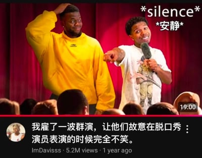 图片展示了一个脱口秀舞台场景，红色幕布背景前站着两位男性。左侧穿黄色卫衣的男子正抓着头发，表情困惑；右侧穿白色T恤的男子手持麦克风，手指着对方，露出得意的笑容。图片右上角有文字“*silence* *安静*”，底部配有评论“我雇了一波群演，让他们故意在脱口秀演员表演的时候完全不笑。”，营造出喜剧表演遭遇冷场的尴尬幽默效果。