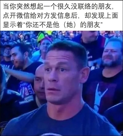 这是一张文字配表情包的搞笑梗图，采用顶部配文、底部配图的结构。顶部文字描述了一个常见的社交尴尬场景：用户突然想起很久没有联络的朋友，点开微信给对方发送消息时，却收到“你还不是他（她）的朋友”的提示，说明自己已经被对方删除好友。下方配图是知名职业摔跤手约翰·塞纳在观众席的真实抓拍，他脸上露出错愕、难以置信的茫然表情，精准对应了遇到上述场景时用户意外、尴尬又错愕的心情，整体极具共鸣感和搞笑效果。