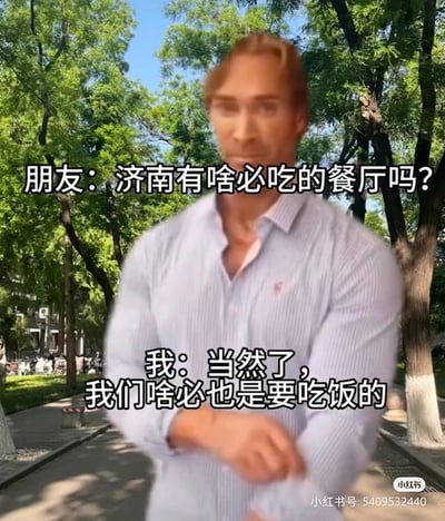 这张梗图展示了一位身穿条纹衬衫、肌肉发达的男子，搭配绿树成荫的公园背景。画面配以方言幽默对白：“济南有啥吃的餐厅吗？”“当然了，我们咋必也是要吃饭的”，利用济南当地方言“咋必”制造亲切与自豪感。整体风格幽默、接地气，常被用来调侃家乡美食或应对外地人询问地方特色。

其中“咋必”在济南方言中意为“怎么可能不”，还带有轻松幽默的双关语气，非常接地气。