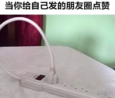 图片上方有黑色文字标题“当你给自己发的朋友圈点赞”，下方是一张实拍照片：白色插线板上，一个白色插头的电线弯曲后插入了插线板自身的插座中，形成自我连接的循环。这种“自己插自己”的荒诞场景，幽默比喻了社交媒体中用户给自己内容点赞的行为，带有自嘲和调侃意味，暗示这种行为如同插头自我供电一样多余却又真实存在。