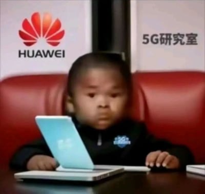 这是一张经过P图合成的趣味梗图，画面中一个面容稚嫩的小孩坐在红色皮椅上，面前摆放着类似笔记本的电子设备，神情严肃，仿佛在专注工作。背景是带有华为品牌标志和“5G研究室”字样的标识，通过将小孩置于专业的科技研究场景中，制造出强烈的反差感，以此调侃华为在5G技术领域的领先地位，用“小专家”的形象营造出幽默搞笑的效果。