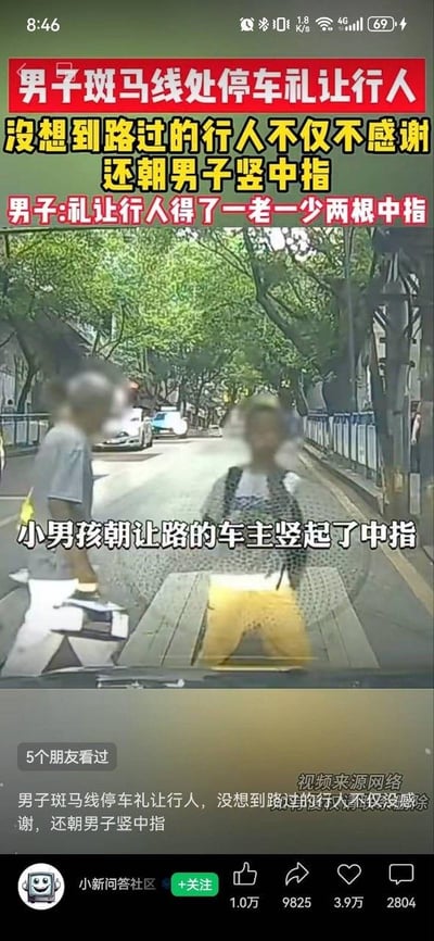 这是一张行车记录仪拍摄的视频截图，画面呈现城市道路的斑马线场景：车主在斑马线前停车礼让行人，然而正在过马路的一老一少两名行人，不仅没有对车主的文明礼让行为表达感谢，反而朝着车内的车主竖起中指。画面的上方、中间和下方都配有醒目的文字说明事件经过：上方文字标注“男子斑马线处停车礼让行人 没想到路过的行人不仅不感谢 还朝男子竖中指”“男子:礼让行人得了一老一少两根中指”，画面中间的字幕特意指出“小男孩朝让路的车主竖起了中指”，下方的文字再次复述事件内容。截图底部显示该内容发布在“小新问答社区”账号下，获得了1.0万点赞、9825次转发、3.9万次收藏以及2804条评论，该事件中车主的善意遭遇恶意回应，引发了网友的关注与讨论。