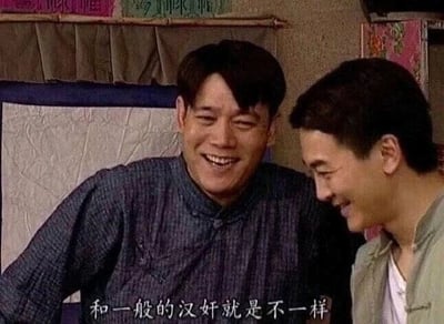 这是一张国产抗战情景喜剧《地下交通站》的剧照截图，画面呈现的是鼎香楼掌柜孙友福和伙计杨保禄的互动场景。两人身处室内，孙友福咧嘴大笑，身体侧倾看向身旁的杨保禄，表情十分夸张；杨保禄则低头含笑，侧身看向孙友福，神态显得十分开怀。画面底部配有字幕“和一般的汉奸就是不一样”，结合剧集的喜剧定位，这句台词是剧中角色在特定语境下的调侃内容，带有强烈的反差喜剧效果，常被网友截取作为梗图使用，用这句看似严肃的台词搭配角色开怀的笑容制造笑点。