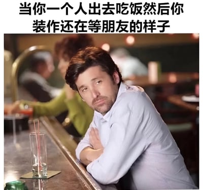 图片展示了一个独自坐在酒吧吧台前的男子，他双臂交叉，表情略显严肃和不自然地望向一侧。图片上方配有文字：'当你一个人出去吃饭然后你装作还在等朋友的样子'，幽默地描绘了独自用餐时为避免尴尬而假装在等待同伴的常见社交场景。