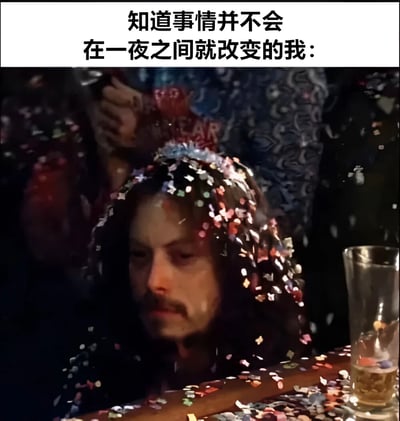 图片上方有文字“知道事情并不会在一夜之间就改变的我：”，下方是一个男人的特写镜头。他周围和头上都落满了五彩纸屑，面前的桌子上也散落着许多纸屑，旁边还有一个装有液体的玻璃杯。尽管身处充满节日气氛的环境中，男人却面无表情，眼神平静地看向下方，形成了一种情绪与场景的反差。