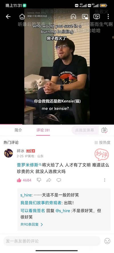 这是一张哔哩哔哩（B站）的视频播放界面截图，视频内容是外网的经典送命题场景：有人向坐在沙发上的戴眼镜男生提问“房子着火了，你会救我还是救Kensie（猫）”，男生身后的沙发上还趴着一只白猫Kensie。而评论区的热门评论玩梗，用普罗米修斯给人类带来火的典故，歪解问题调侃“这么珍贵的火，就没人选救火吗”，引发其他网友回复觉得好笑，用偏离问题的脑洞回答制造出幽默效果，无特殊双关或谐音梗，纯粹是神回复带来的笑点。