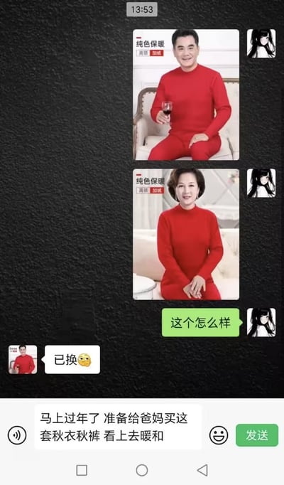 整张图是智能手机端的即时通讯聊天界面截图，背景为黑色纹理，顶部显示时间13:53。头像是黑白动漫女性形象的用户先后发送了男款、女款大红色高领加绒中老年保暖内衣的商品宣传图，随后发消息询问对方“这个怎么样”；而对方的头像正好和男款保暖内衣的模特图完全一致，回复内容为“已换”搭配一个无奈的黄脸表情。界面底部的输入框中还有未发送的文字，内容是发图用户准备过年给爸妈买这套秋衣秋裤，觉得看上去很暖和，整体因头像和商品图撞款的巧合充满喜剧效果。