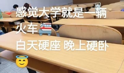 这张梗图拍自大学教室，空荡的课桌椅代表了日常的大学课堂气氛。配文“感觉大学就是一辆火车🚅 白天硬座 晚上硬卧”用火车座位的梗来形容大学生活的疲惫：白天上课像坐硬座（辛苦、累），晚上睡觉像硬卧（条件一般）。既搞笑又扎心，充分展现大学生自嘲与调侃生活的风格。

双关梗解析："硬座"和"硬卧"既指火车座位类型，也隐喻大学生上课和休息都很不舒适。