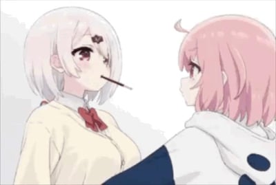 这是一段动态GIF，画面呈现两位二次元少女的互动：浅白发色、佩戴深色发饰的少女嘴里叼着一根类似Pocky的长条形饼干，面带羞涩又带着期待的神情，朝着粉发色、头顶有呆毛的少女靠近；粉发少女则带着惊讶又略带羞涩的眼神注视着对方，整体氛围充满暧昧的百合向气息，还原了ACG文化里经典的Pocky游戏场景，这类场景常用来表现角色间的亲密情愫。
