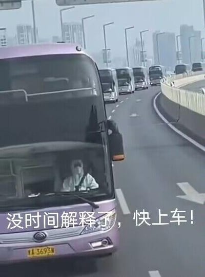 这是一张经过文字加注的实拍改编图，画面展示了一辆行驶在城市高架道路上的宇通大巴，司机正看向镜头，图片下方添加了网络热梗文字「没时间解释了，快上车！」。这句配文常被用来营造急切的氛围，以戏谑的方式催促他人快速加入某个行动、话题或活动，多用于社交场景中的互动邀请。