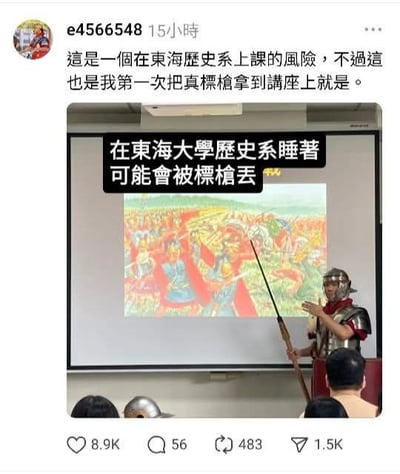 社交媒体用户e4566548分享的东海大学历史课现场：一名身着罗马风格盔甲的演示者手持标枪站在讲台前，身后投影仪屏幕显示着色彩鲜艳的古代战争画作。帖子配文提到这是首次将真标枪带到讲座，图片叠加文字幽默调侃“在东海大学历史系睡着可能会被标枪丢”，展现了历史课生动有趣的教学场景。