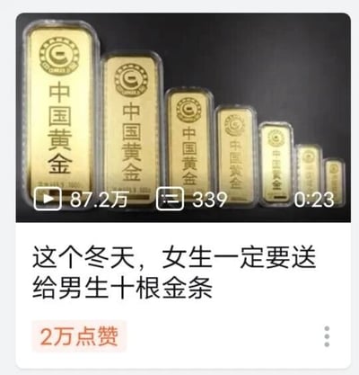 这是一张短视频平台的视频截图，画面上半部分展示了七根从大到小依次排列的中国黄金金条，每根金条上都印有“中国黄金”的字样和品牌专属标识；视频的基础数据显示其播放量为87.2万，评论数339，时长23秒。画面下半部分配有文字“这个冬天，女生一定要送给男生十根金条”，该内容收获了2万点赞，是一则围绕冬季送礼话题展开的短视频，提议女性在冬季赠送男性十根中国黄金金条作为礼物，借黄金的价值和寓意打造相关话题内容。