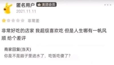 这是一张2021年11月11日的美团平台评价界面截图，图中显示一位匿名美团会员给商家打出了一星“非常差”的评价，但评价内容却明确表示“非常好吃的店家 我超级喜欢吃”，给出差评的理由仅仅是“人生哪有一帆风顺”，属于完全无厘头的无理由差评；商家在当天进行了回复，语气十分愤怒，直接指责用户“你是不是脑子里进水了，吃饭吃傻了？”，整个互动充满了荒诞感和趣味性，展现了因毫无道理的差评引发的激烈商家回应。