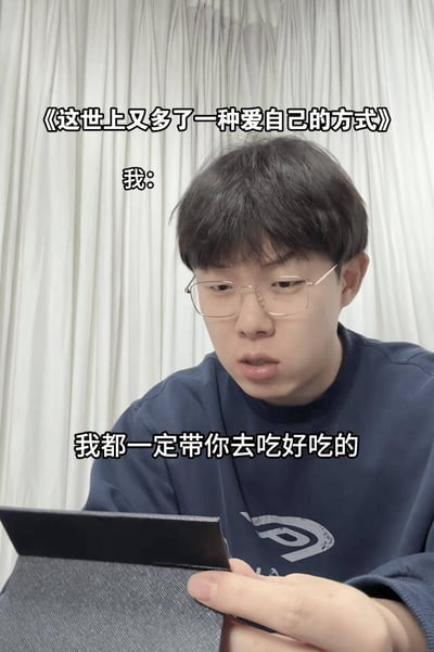这是一张真人拍摄的图文混排梗图，背景为白色竖纹布艺窗帘，画面主体是一名佩戴细框眼镜、身穿深蓝色卫衣的年轻男子，他正手持带灰色保护套的平板类电子设备，低头注视屏幕，表情认真郑重。图中搭配了三段文字：顶部是标题式文字《这世上又多了一种爱自己的方式》，标题下方标注「我:」，画面最下方是男子的台词「我都一定带你去吃好吃的」，内容呈现的是人们对自己许下美食承诺、用犒劳自己的方式好好爱自己的日常心态，容易引发年轻人的共鸣。