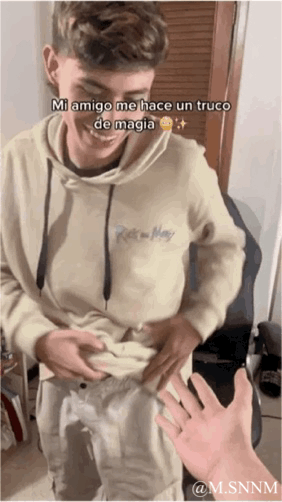 这是一段搞笑GIF动态图，画面中一名男生大笑着掀起自己的卫衣，下方有一只手配合做出“拿走肚子”的动作，利用视觉错位制造出“魔术”效果。图上方的西班牙语文字为“Mi amigo me hace un truco de magia 😂✨”，翻译为“我的朋友给我变个魔术”，整体是朋友间轻松滑稽的整蛊互动场景，通过简单的视觉错位带来搞笑的反差感。