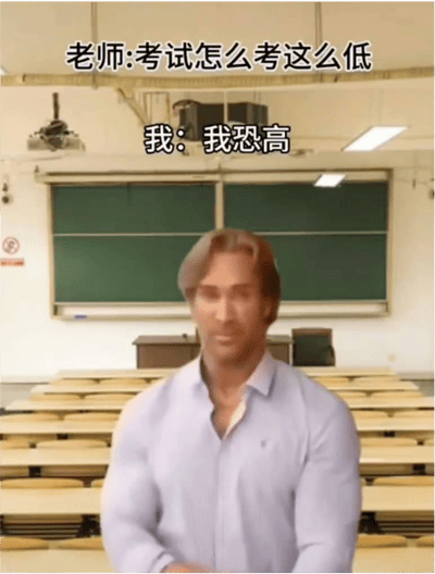 图片中是美国健身网红迈克·奥赫恩站在教室场景中，背景可见绿色黑板和排列整齐的课桌椅。画面上方配有两行对话文字：“老师:考试怎么考这么低”和“我:我恐高”，通过毫无逻辑关联的回答形成“大力王文学”特有的幽默讽刺效果，展现了对盲目自信态度的戏谑。