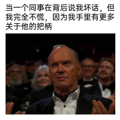 这是一张结合影视截图与网络段子的搞笑职场梗图，图上方配有文字“当一个同事在背后说我坏话，但我完全不慌，因为我手里有更多关于他的把柄”，下方是美国演员迈克尔·基顿在奥斯卡颁奖典礼现场的实拍截图，他身着正式的黑色西装礼服，双手抬起做鼓掌动作，面部表情平静沉稳，眼神中带着一种胸有成竹的审视感。配文与人物表情的结合，精准地刻画出职场中当自身掌握他人把柄时，面对对方小动作的淡定、从容甚至略带掌控感的心态，用幽默戏谑的方式调侃了职场里复杂的人际关系与自保的生存法则，容易引发职场人士的共鸣。