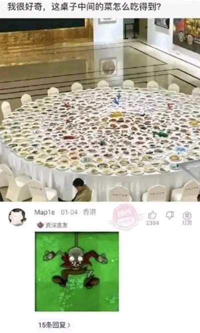 这是一张上下拼接的社交媒体互动内容图，上方为实拍场景：一个直径极大的圆形餐桌铺满了各色菜肴，周围摆放着白色餐椅，一名人员坐在餐椅上，配文提出疑问“我很好奇，这桌子中间的菜怎么吃得到？”，由于餐桌尺寸过大，桌边的人显然无法直接够到中间的菜品。下方是网友Map1e的回复内容，该用户标注为“资深皮友”，来自香港，他使用了经典塔防游戏《植物大战僵尸》里蹦极僵尸的截图来回复，蹦极僵尸的设定是从空中吊下，能够越过障碍获取目标，以此趣味调侃可以模仿这个僵尸的方式，从上方吊下来吃到桌子中间的菜，用游戏角色的特性巧妙回应了原问题，充满搞笑趣味。