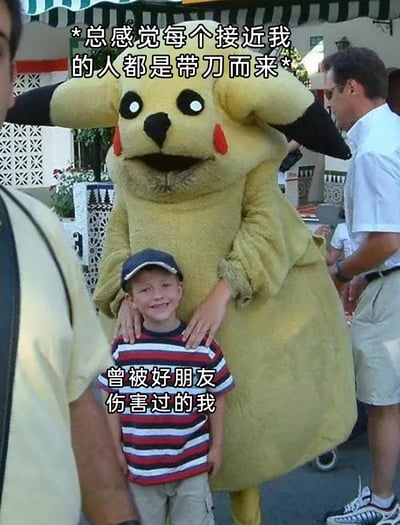 这是一张经过文字改编的搞笑梗图，主体是一个还原度较低的皮卡丘玩偶服扮演者，双手放在一个面带笑容的小男孩的肩膀上，这个姿势因视觉错位看起来像是要用力伤害小男孩。图中添加了两段文字，上方是“*总感觉每个接近我的人都是带刀而来*”，下方是“曾被好朋友伤害过的我”，用这个具有反差感的画面，生动地表现出曾经被好友伤害后，对身边人充满防备、多疑的心理状态，以幽默的方式放大了这种在人际关系中受伤后的敏感情绪。