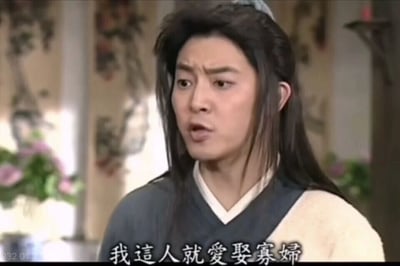 这是一张国产经典情景喜剧《武林外传》的截图，画面中的角色是同福客栈的跑堂白展堂，他原本是江湖上的盗圣，此刻眉头微皱，嘴巴张开，面露激动的神情，似乎在大声表达自己的想法。图片底部配有他的台词字幕：“我这人就爱娶寡妇”，这句台词是他在剧中特定情节里的发言，用来表达当下的情绪或是应对所处的状况，整体画面还原了剧中充满喜剧感的场景氛围。